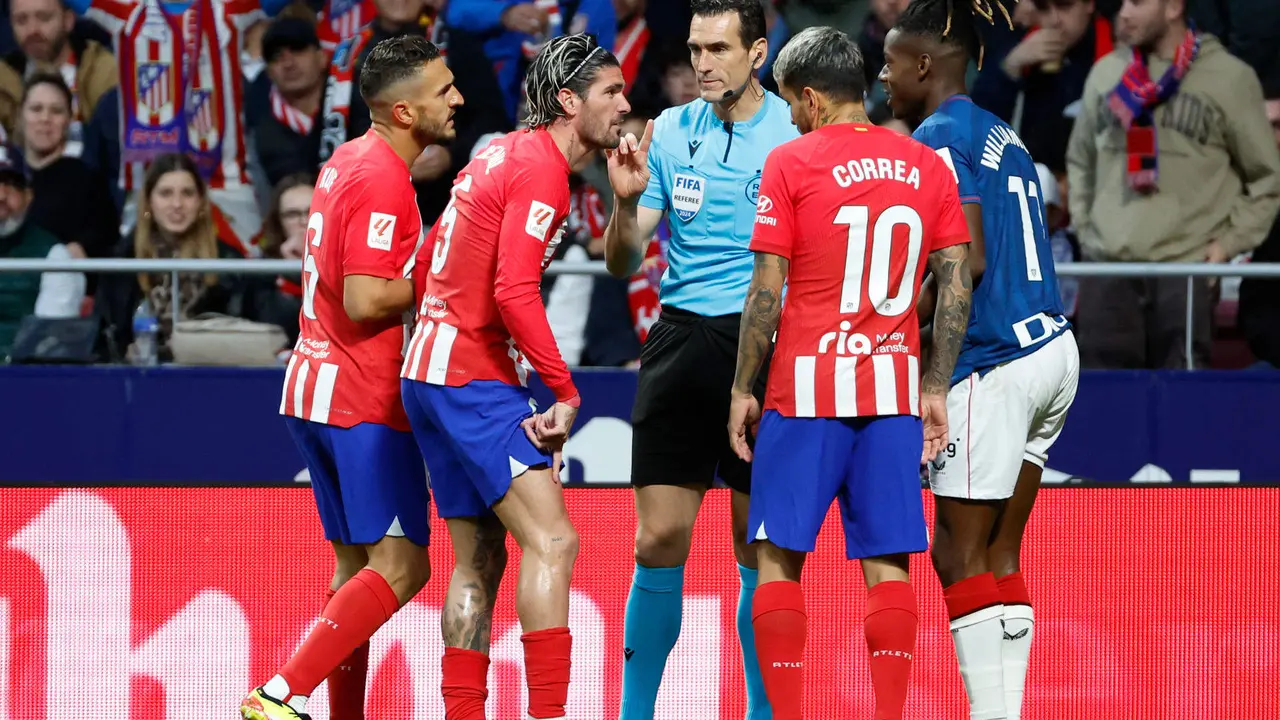 Jugadores del Atlético de Madrid conversan con el árbitro Martínez Munuera durante un partido de la Liga española. EFE/Mariscal